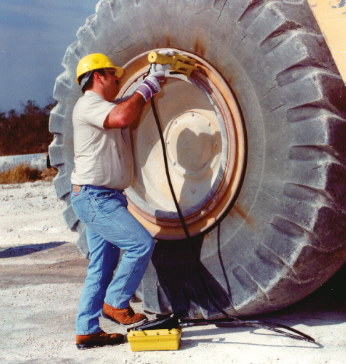 Демонтаж шины бортоотжимателем с карьерного самосвала не снимая колесо с машины