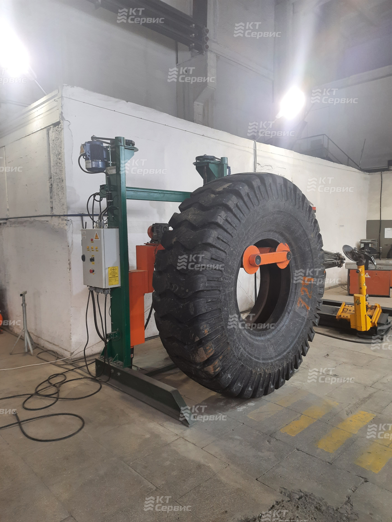 Крупногабаритная шина установленная на стойку-подъемник шиноремонтную г/п 4500 кг для ремонта КГШ 33”-57”
